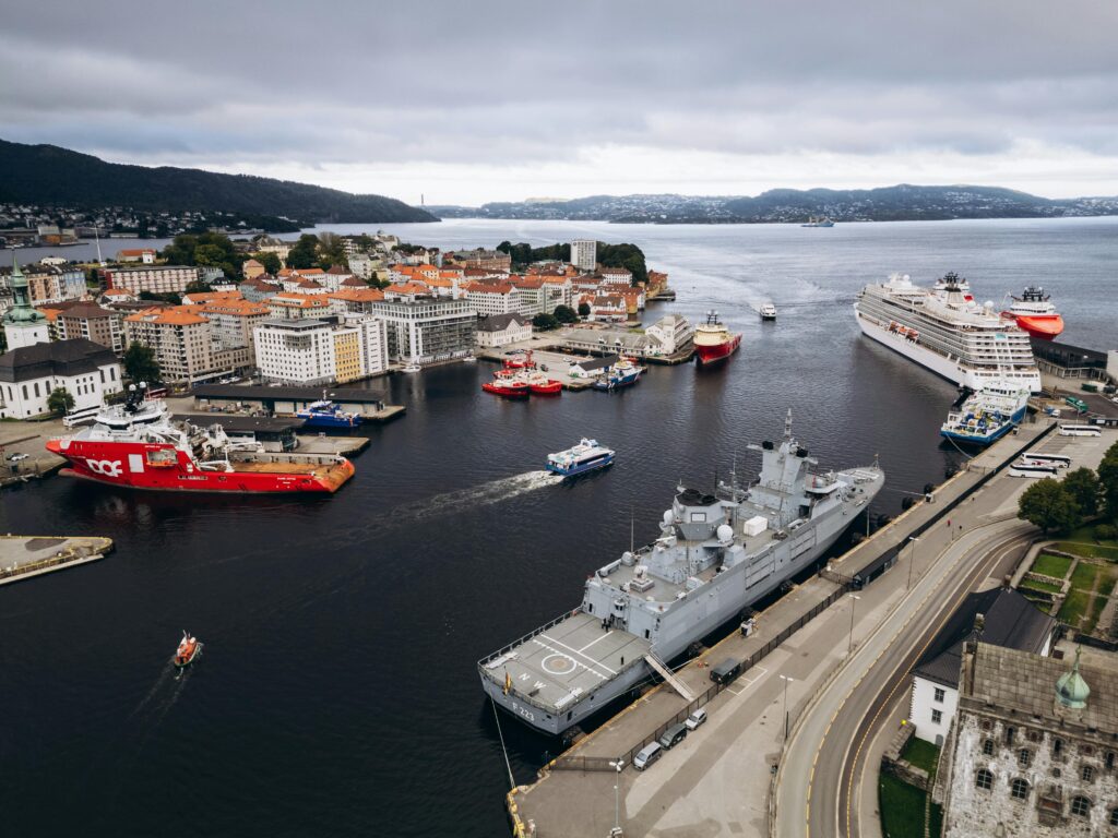 Explore Bergen's vibrant harbor with ships and scenic views, an iconic part of Norway's coastal charm.